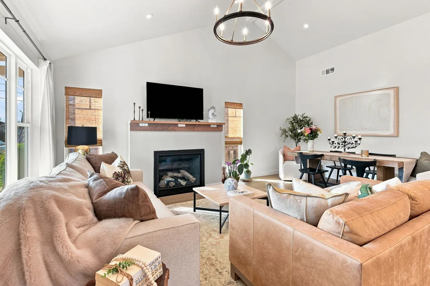 Living room looking toward the dining area, with the fireplace and wood mantel under the vaulted ceiling